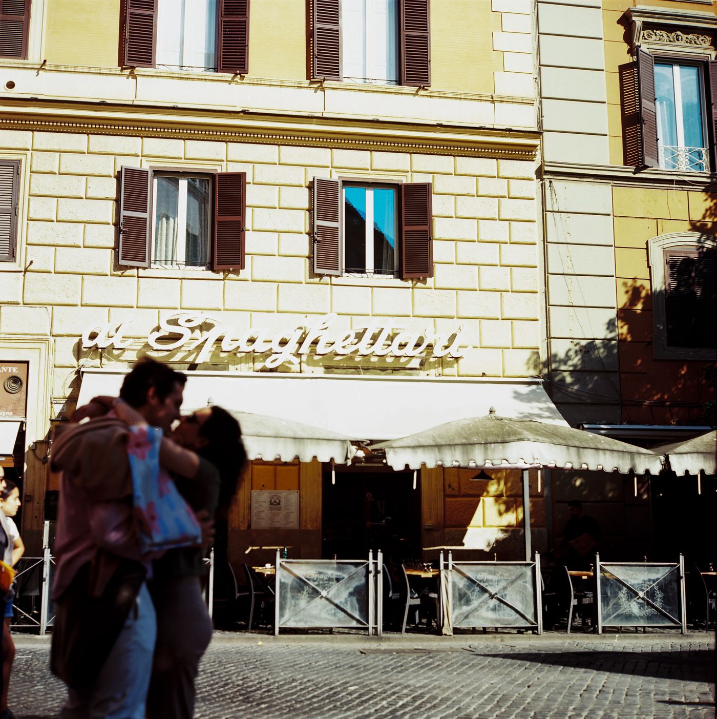 Two people embracing outside a restaurant in Rome